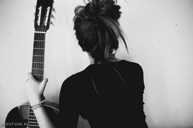 Черно-белое фото девушки с гитарой.