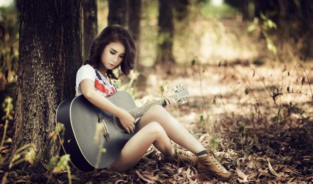 Девушка в лесу с гитарой.