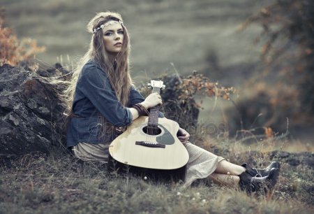 Девушка на пляже с гитарой.