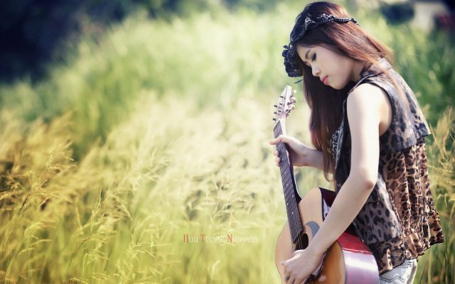 Девушка в поле с гитарой.