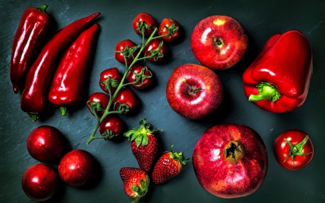 Красные овощи и фрукты на столе.