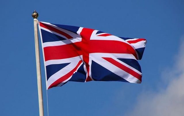 Британский флаг на фоне голубого неба.