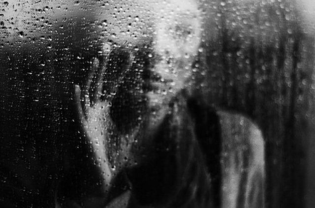 Девушка, капли дождя на стекле.