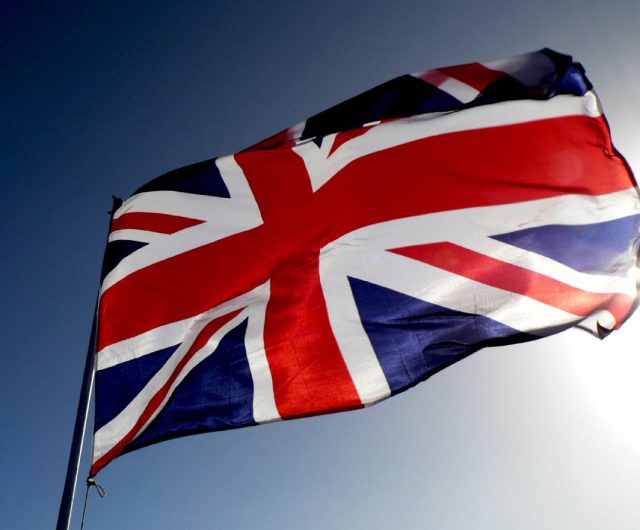 Британский флаг на фоне голубого неба.