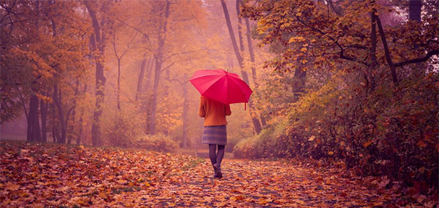 Девушка с красным зонтиком в парке.