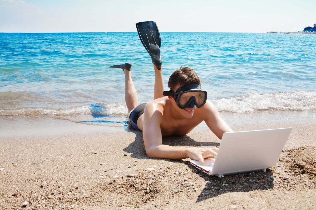 Мужчина с ноутбуком на пляже