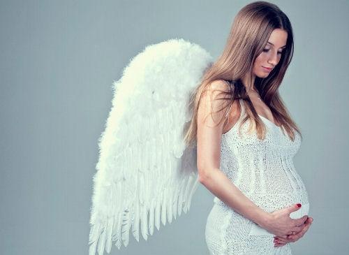 Беременная женщина в костюме ангела.