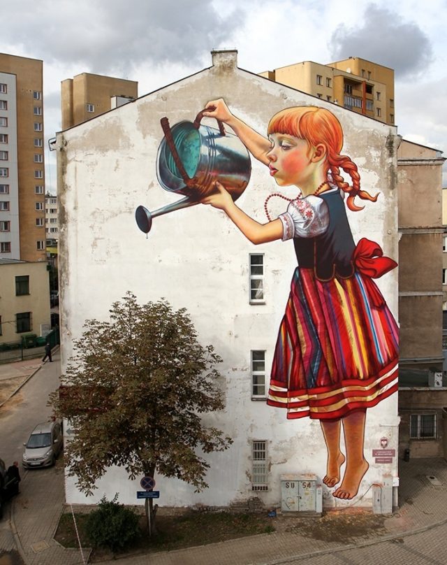 Девочка поливает дерево.