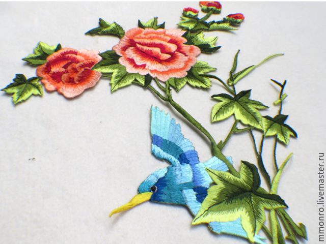 Голубая птичка возле цветов.