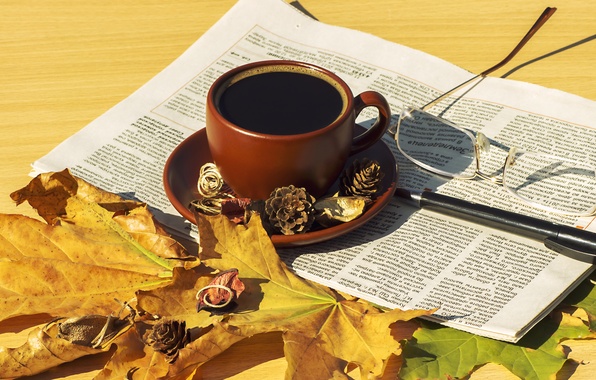 Листья, газета, кофе на столе.