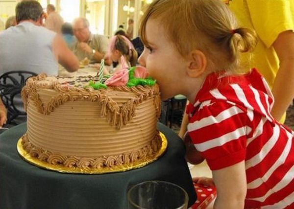 Девочка кусает торт.